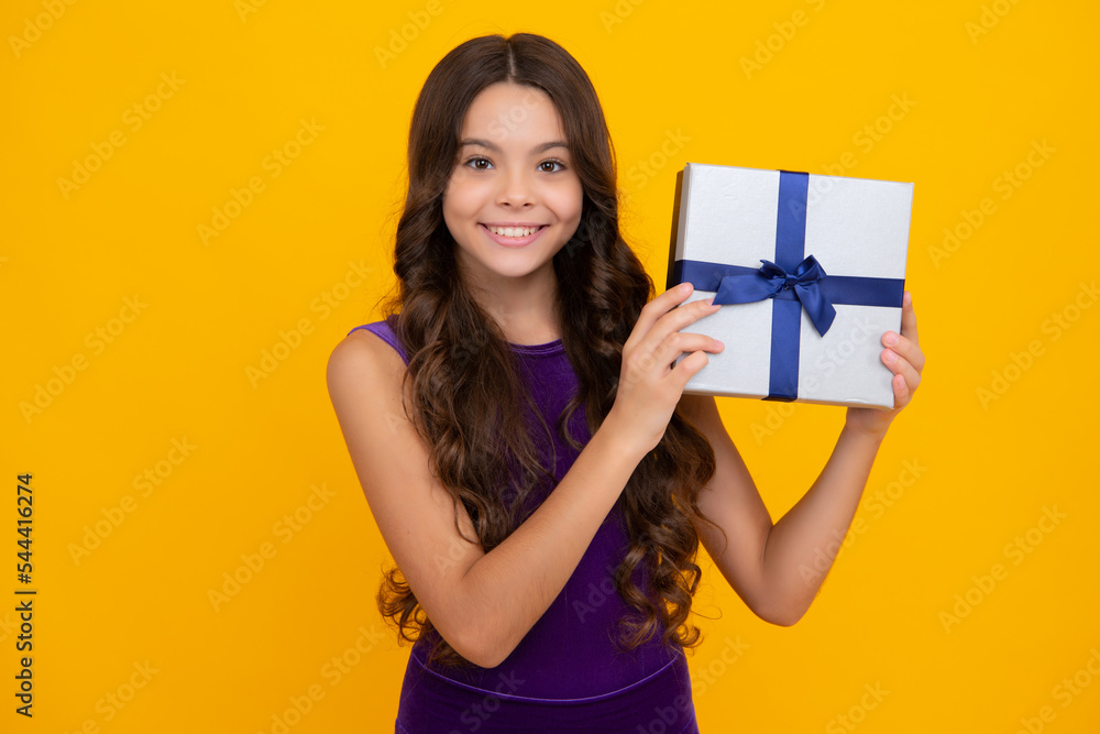Happy girl face, positive and smiling emotions. Child with gift present box on isolated studio background. Gifting for kids birthday. Happy girl face, positive and smiling emotions. Child with gift present box on isolated studio background. Gifting for kids birthday.