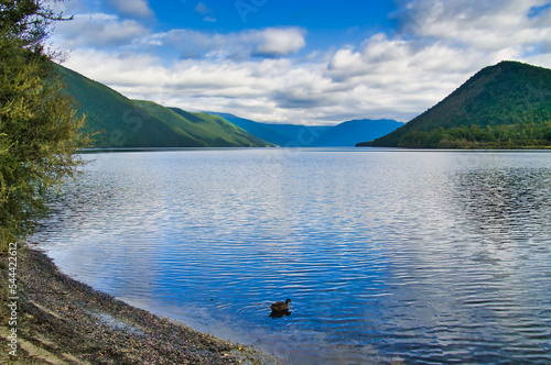 Clouds and blue sky reflecting in the water of Lake Rotoroa, Nelson Lakes National Park, Tasman region, South Island, New Zealand. 