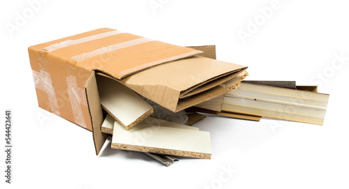 a pile of construction debris (plastic, MDF, aluminum, cardboard) in a brown cardboard box on a white background