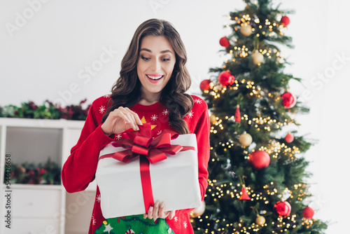 Photo of astonished lovely positive lady stand indoors cozy houseroom open gift box impressed size weight like unexpected gift photo