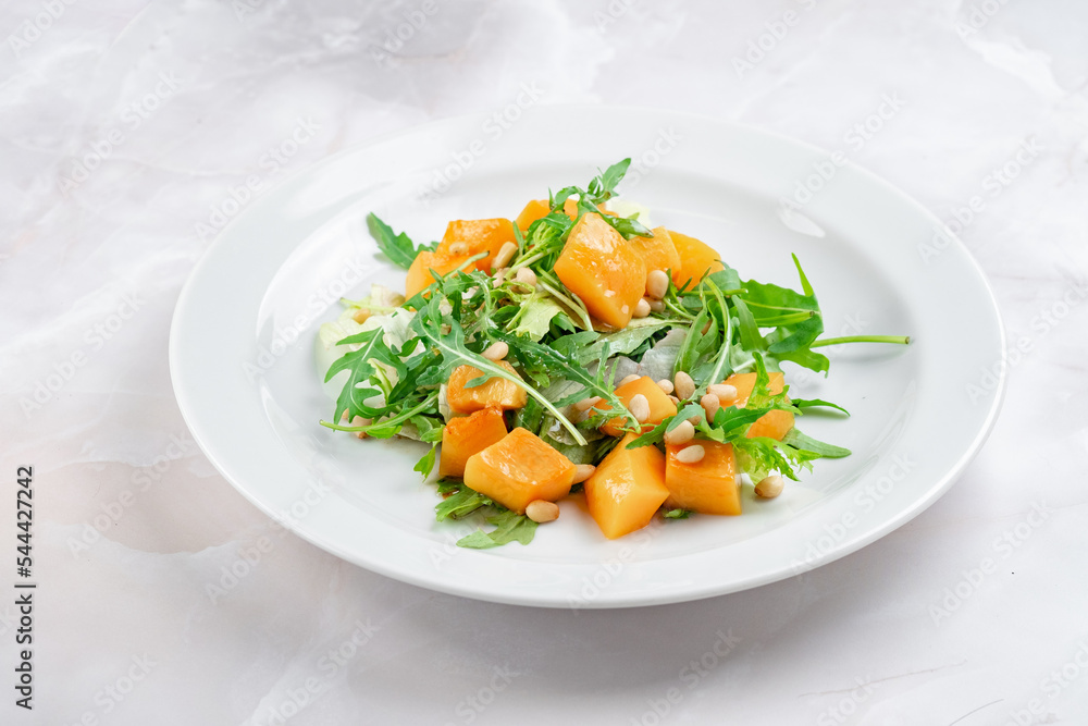 Italian vegetarian salad of baked pumpkin with pine nuts, arugula and cheese. Bright fresh salad with pumpkin slices Italian vegetarian salad of baked pumpkin with pine nuts, arugula and cheese. Bright fresh salad with pumpkin slices