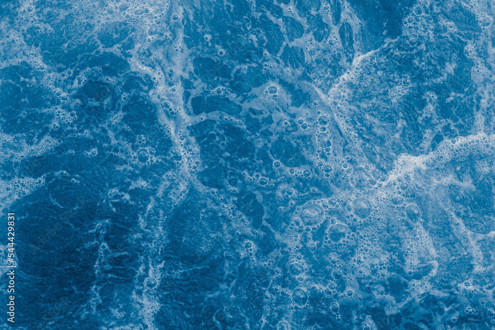Fototapeta premium Dark blue sea surface with waves, splash and bubbles