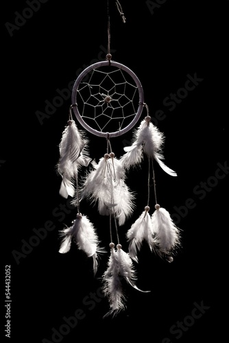 A dream catcher made of white feathers on a black background