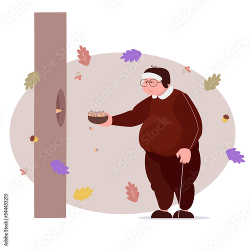 grandfather feeds a squirrel with acorns in the autumn period
