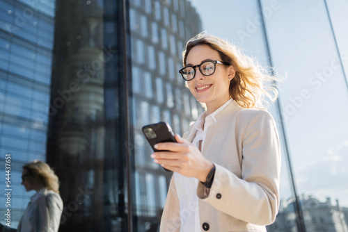 Fotografía Uses a phone device in his hands, communicating with a colleague