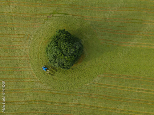 A drone shot of a tractor turning grass in a meadow near the Yorkshire Dales village of Malham, North Yorkshire.
