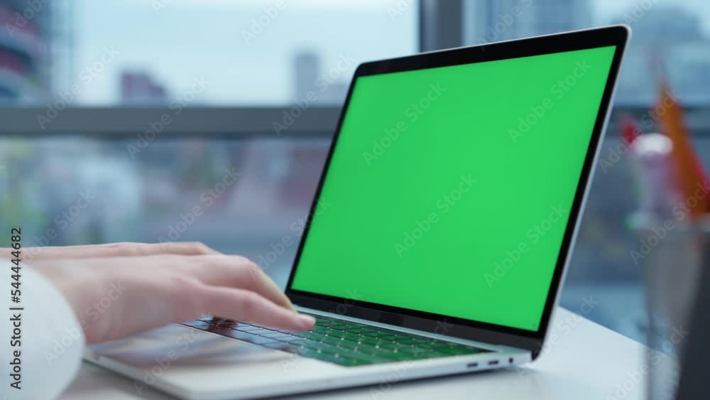 Laptop with Green Mock-up Screen Close-up. Business Lady or IT Specialist Works Sitting at Table with Notebook Laptop with Green Mock-up Screen Close-up. Business Lady or IT Specialist Works Sitting at Table with Notebook