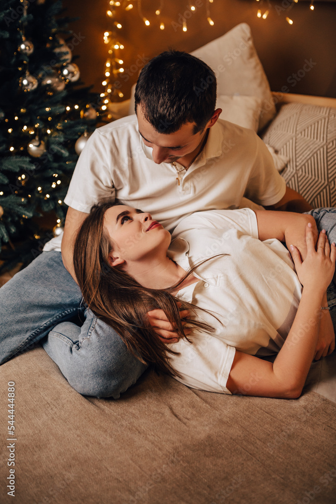 Vertical image lovely young romantic couple lying on bed garlands kissing hugging home cosy interior atmosphere New Year Christmas tree decorations holiday party celebrating concept winter evening
Vertical image lovely young romantic couple lying on bed garlands kissing hugging home cosy interior atmosphere New Year Christmas tree decorations holiday party celebrating concept winter evening