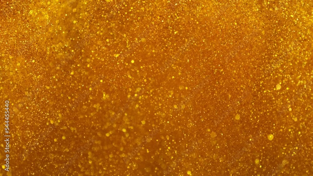 Super slow motion of glittering golden particles. Isolated on black background. Shallow depth of focus. Filmed on high speed cinema camera, 1000 fps. Super slow motion of glittering golden particles. Isolated on black background. Shallow depth of focus. Filmed on high speed cinema camera, 1000 fps.