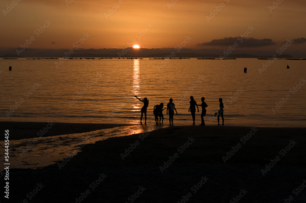 Children playing in the beach at the sunset. Lapaman Beach.