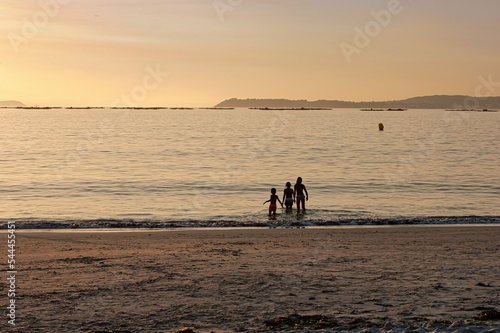 Children bathing in the beach at the sunset. Lapaman Beach.