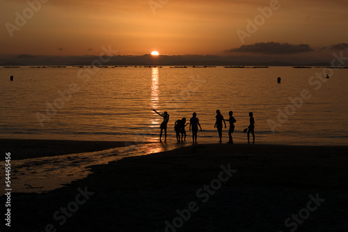 Children playing in the beach at the sunset. Lapaman Beach.