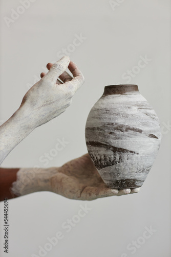 Fototapete Closeup of black man holding handmade ceramic vase, art and artist concept