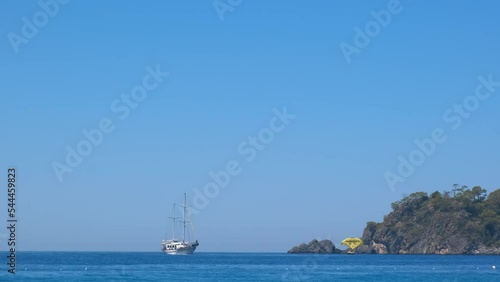 Luxury ships in blue bay under sun. A fantactic view of boating ship by the green hills in the blue water of ocean. photo