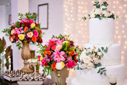 a 4-tier wedding cake, and flower arrangements on a table