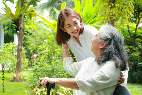 Family concept. daughter taking care of elderly mother at home They both smiled happily in the front yard. A caregiver or nurse takes care of a senior in a health center.