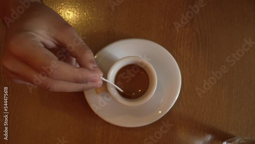 Close up on hand of unknown caucasian man stirring a cup of coffee photo