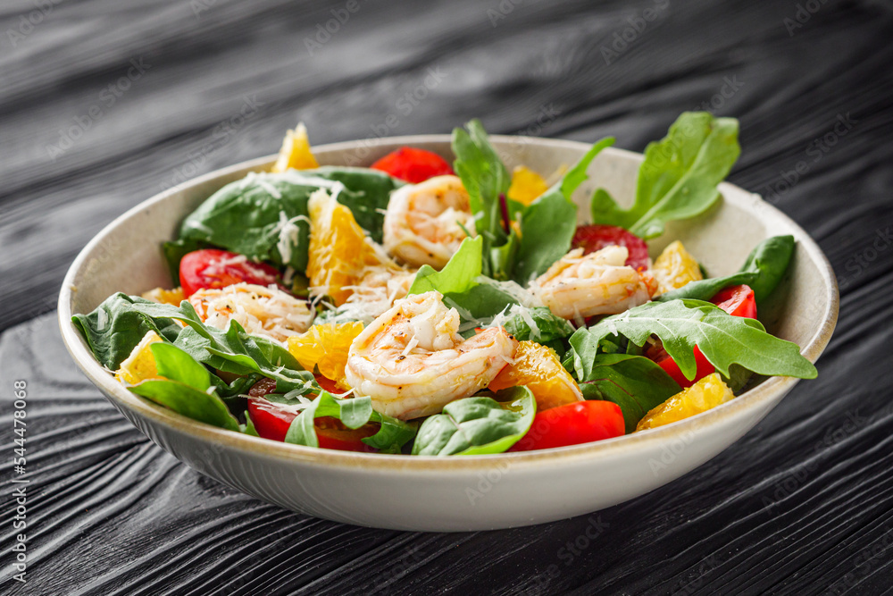 delicious fresh shrimp salad with orange and cherry tomatoes on a black wooden rustic background delicious fresh shrimp salad with orange and cherry tomatoes on a black wooden rustic background