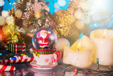 christmas background with christmas candles and a glass ball with santa claus