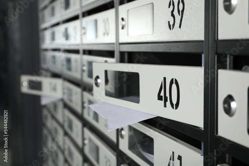 Open mailboxes with keyholes, numbers and receipts, closeup © New Africa