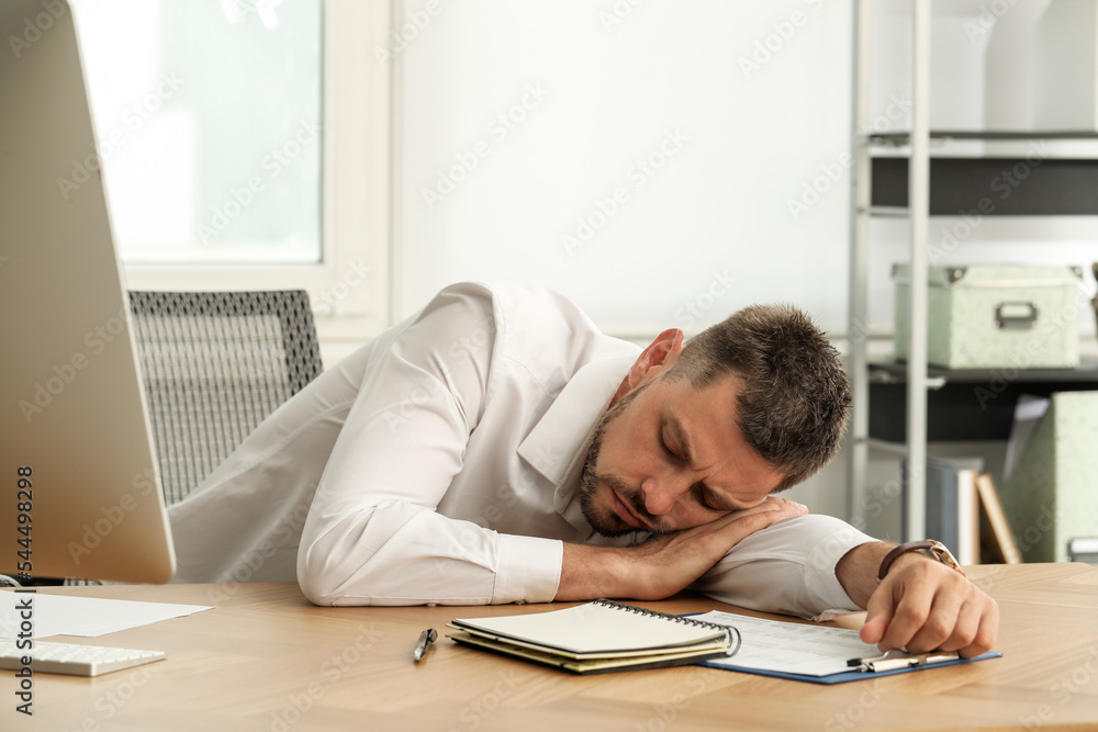 Tired man sleeping at workplace in office Tired man sleeping at workplace in office