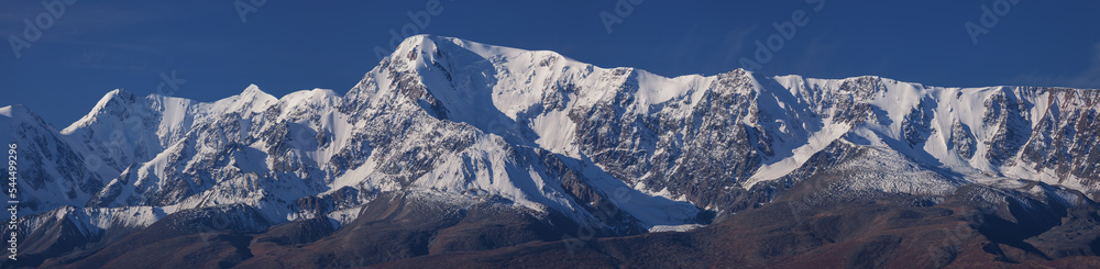 Snow-capped mountain peaks, contrasting morning light, large panorama