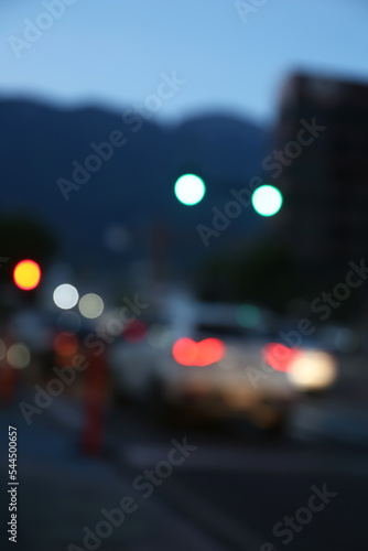 Blurred view of modern city and road with cars. Bokeh effect