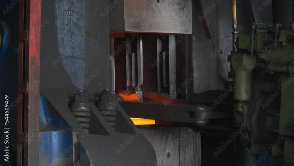 Blacksmith factory. Forging a large hot metal billet with an industrial ...