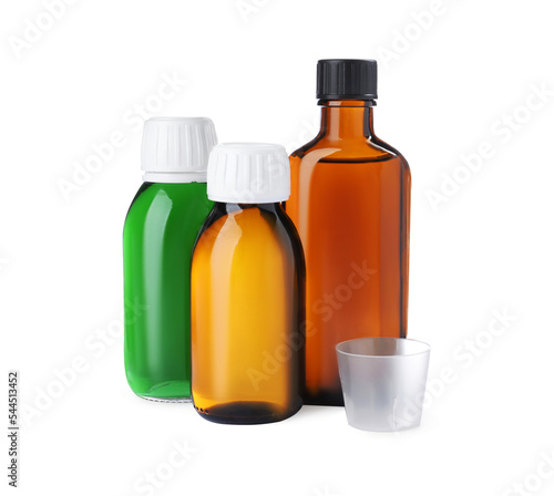 Bottles of syrups with measuring cup on white background. Cough and cold medicine