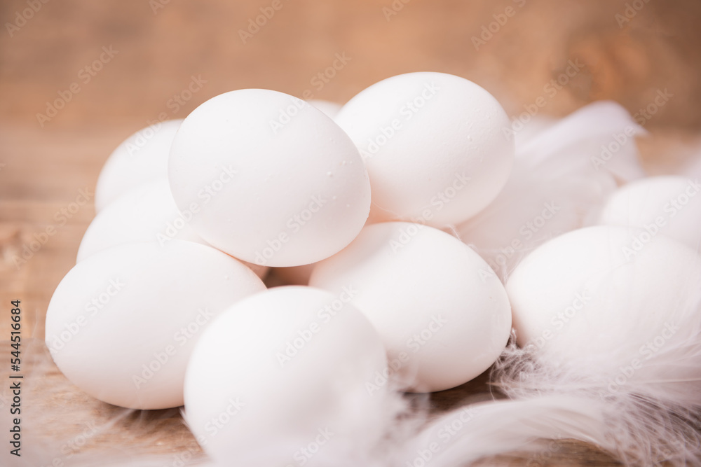 Fresh white eggs and feathers Fresh white eggs and feathers