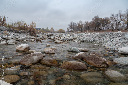 Slow and not deep mountain river with rounded stones