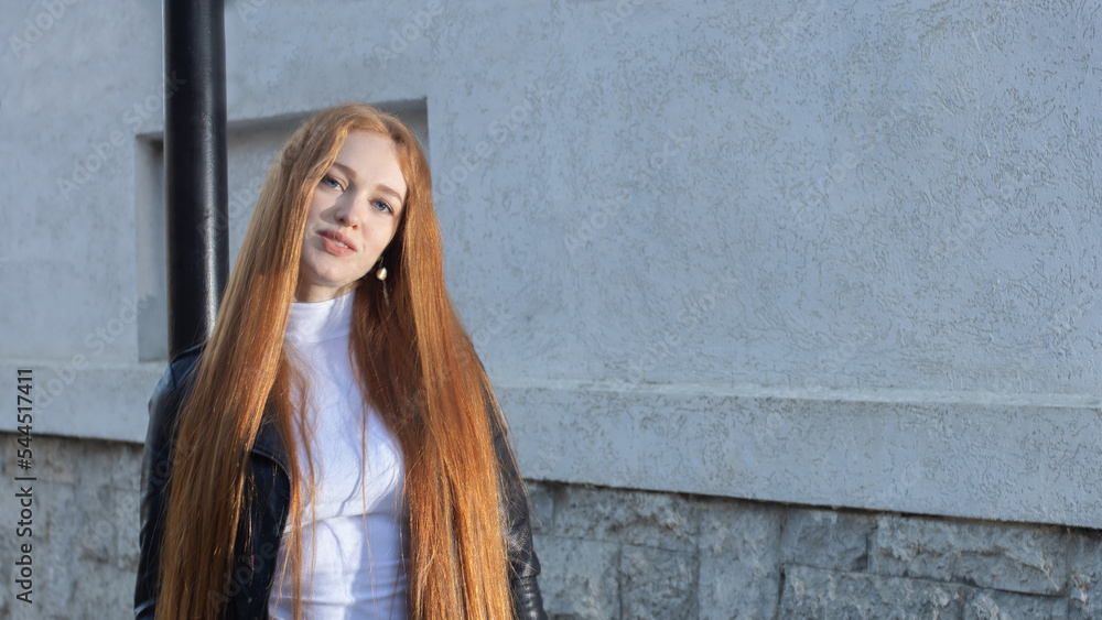 beautiful girl, model, in a leather jacket, with long hair posing on the street beautiful girl, model, in a leather jacket, with long hair posing on the street