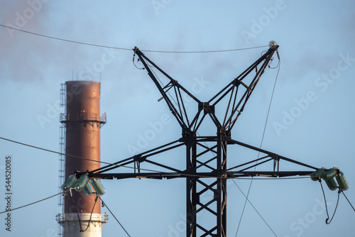 Lattice-type overhead power line tower and power plant chimne photo