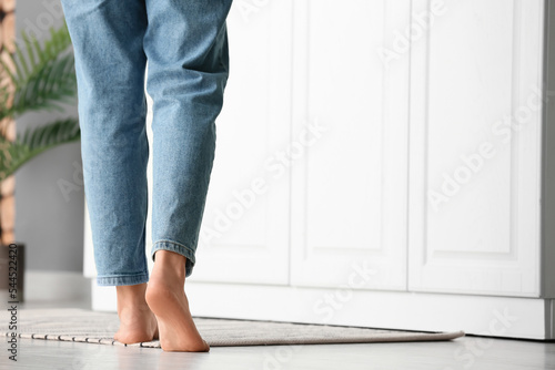 Female barefoot legs on carpet in kitchen