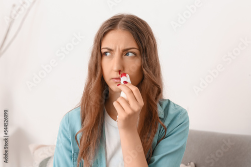 Young woman wiping noseblee...