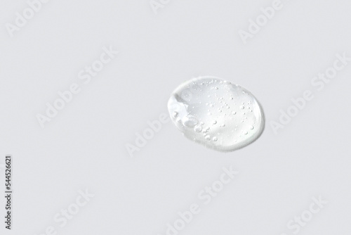 Ttransparent cosmetic smear sample with bubbles texture on light grey background. Skin care y body treatment