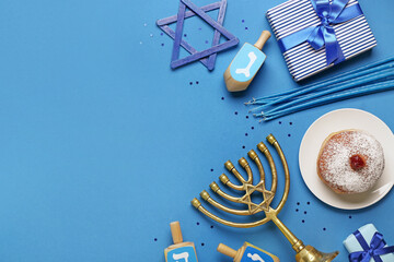 Plate with tasty doughnut, menorah, dreidels and gifts for Hanukkah celebration on blue background