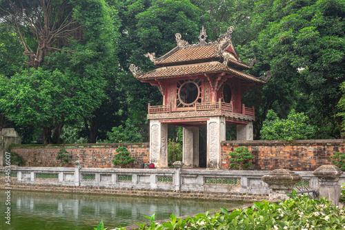 Colorful traditional tower pagoda structure and pond at the gardens of the Temple Of Literature in Hanoi Vietnam