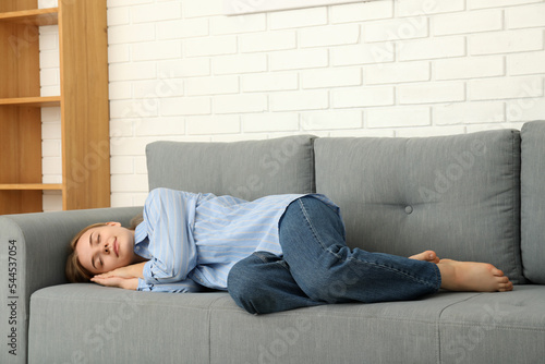 Young woman sleep on sofa in cozy modern flat