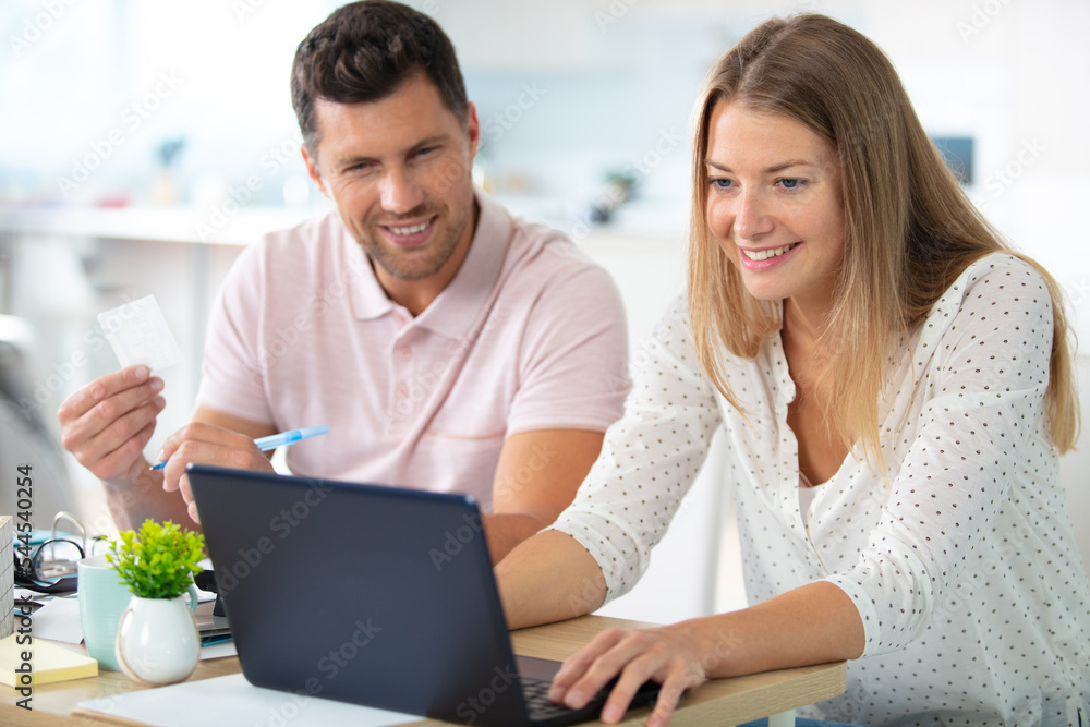 happy beautiful couple using laptop together happy beautiful couple using laptop together