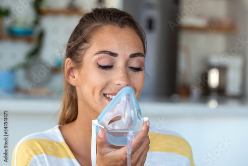 Sick woman making inhalation, medicine is the best medicine. Ill woman wearing an oxygen mask and undergoing treatment for covid-19. woman with an inhaler