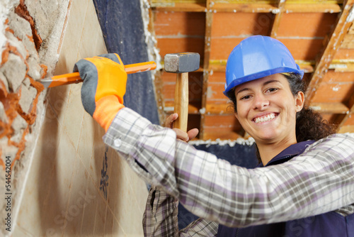 happy female builder with hammer and chisel