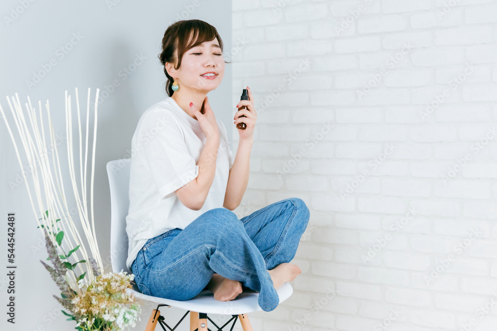 Fototapeta premium 椅子に座りながらネックケアするアジア人女性（首） 