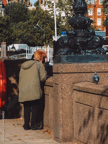 laddy feeding the pigeon in the street photo