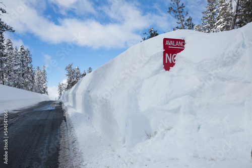 No stopping avalanche zone sign buried in snow on a mountain pass