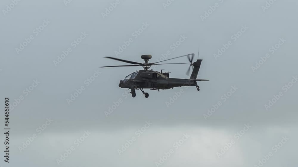 close-up of British army Boeing Apache Attack helicopter gunship (AH-64E AH64E ZM707 ArmyAir606) flying low and banking, grey cloud sky, Wilts UK close-up of British army Boeing Apache Attack helicopter gunship (AH-64E AH64E ZM707 ArmyAir606) flying low and banking, grey cloud sky, Wilts UK
