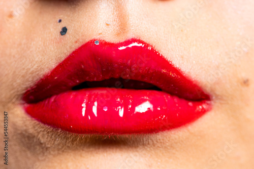 Close-up of woman with red lipstick touching face