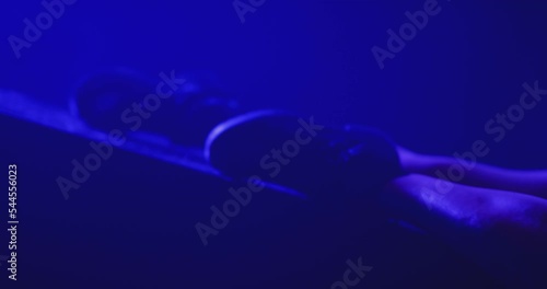 Closeup view of beautiful sexy woman dancing, posing and flirting inside dark place. Sensual scene of female model doing different sexy movements . Female model with g-string and tattoos in strip club