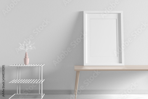 white blank frame on the table leaning against the wall