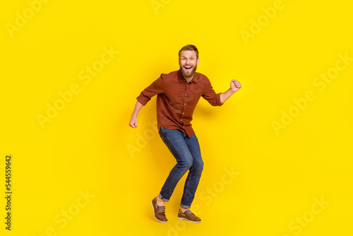 Full size portrait of overjoyed cheerful man chilling dancing clubbing isolated on yellow color background